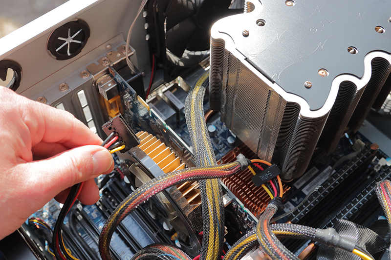 Hand holding a cable fixing a computer